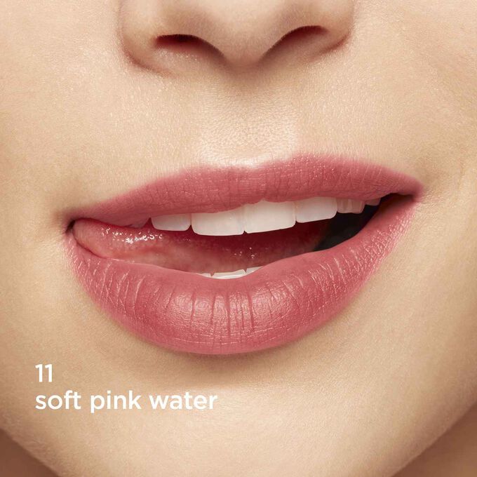 Primo piano di labbra che sorridono per mostrare la texture e il colore della tinta labbra rosa sull’incarnato