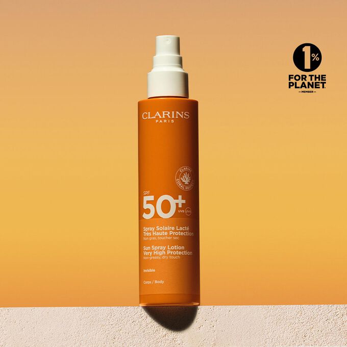 Packshot spray di lozione solare corpo fattore 50 con un messaggio che annuncia l’impegno Clarins a tutela dell’ambiente
